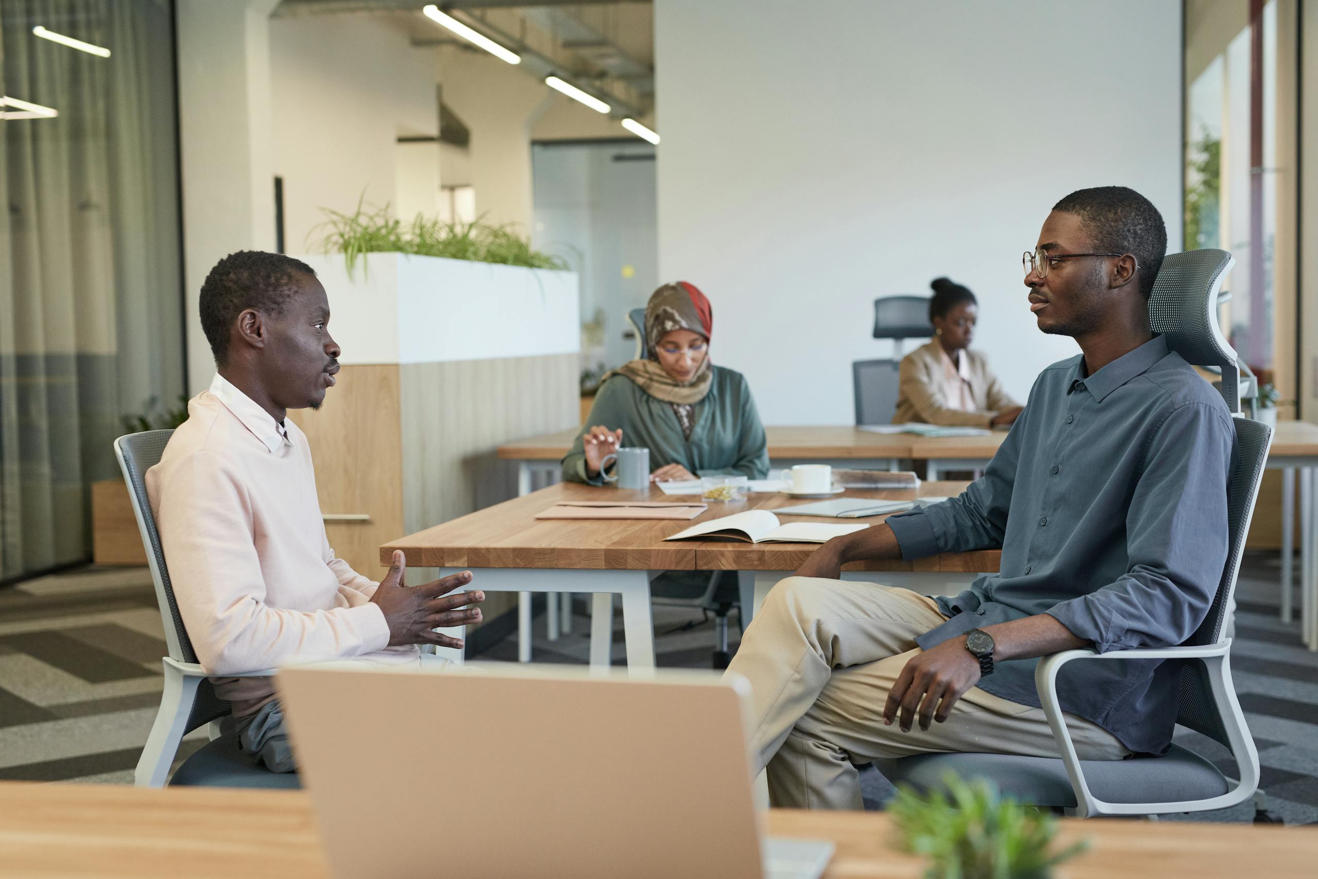 A diverse team engages in a collaborative discussion in a modern office setting, fostering teamwork.